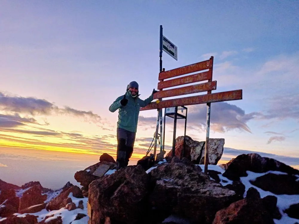 image of a trekker reaching Point Lenana summit on Mount Kenya at sunrise